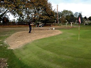 Volunteer Mike Thomas rakes the reconditioned surface of the second hole at Port Townsend Golf Club. A volunteer crew along with course staff removed a mossy stretch of green