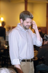 Mark Ozias joyfully informs his father over the phone he has garnered over 50 percent of ballots in the first count Tuesday evening at the Emerald Northwest Grill & Public House in Sequim. Chris McDaniel/Peninsula Daily News