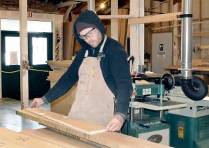 Port Townsend School of Woodworking faculty member Cedar Knoll measures a board that will be used as a template while in the school's production facility. Charlie Bermant/Peninsula Daily News