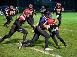 Port Townsend's Keegan Khile (58) and Jacob Ralls (3) stop the progress of Bellevue Christian's Dylan Parsons during the Redhawks' play-in game victory at Memorial Field in Port Townsend. Steve Mullensky/for Peninsula Daily News