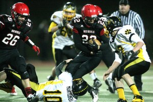 Neah Bay running back Cody Cummins (22) battles for extra yards late in the second half while Cusick's Quinton Montgomery (10) and Tyson Shanholtzer (12) get in on the tackle. David Willoughby/for Peninsula Daily News