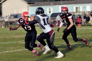 Neah Bay's Anthony Bitegeko (13) prepares to tackle Lummi's Dashawn Lawrence (10) as Roland Gagnon runs to help during the Red Devils 62-12 victory over the Blackhawks earlier this season. The two teams meet for the fourth consecutive year in the state semifinals today at 1 p.m. at the Tacoma Dome. Lonnie Archibald/for Peninsula Daily News
