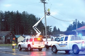 LaPush firemen and law enforcement look on after blocking Spruce Street in LaPush on Tuesday morning while a Clallam County Public Utility District worker disconnects lines that came down when a utility pole broke. Lonnie Archibald/for Peninsula Daily News
