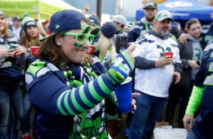To inspire you — a fan takes a picture with a phone while tailgating before the game between the Seahawks and the Arizona Cardinals on Nov. 23 in Seattle. The Associated Press
