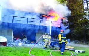 Firefighters battle a house blaze in the 300 block of North Bay Way in Port Ludlow on Friday afternoon. Bill Beezley/East Jefferson Fire-Rescue