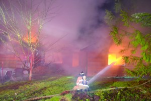 A firefighter battles a blaze on Holcomb Street in Port Townsend early Monday morning.  Bill Beezley/East Jefferson Fire-Rescue