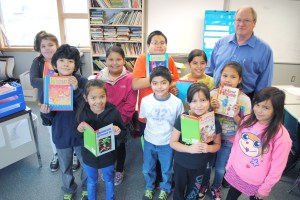 Quileute third-graders and their instructor show off some of the books donated to the school by McGraw-Hill Publishers in thanks for assistance with correcting the book Quileute Legends. Emily Foster/Talking Raven