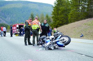 Jefferson County Sheriff Tony Hernandez speaks with Deputies Darren Dotson and Brandon Przygocki at the scene of an accident on state Highway 104 east of the U.S. Highway 101 junction. The crash sent the rider of this motorcycle to Harborview Medical Center in Seattle on Thursday afternoon.  Joe Smilie/Peninsula Daily News