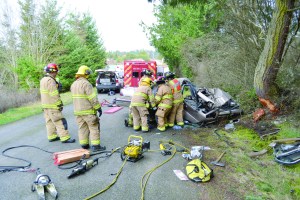 Firefighters use the hydraulic Jaws of Life to remove two people from a car that crashed into a tree in Port Townsend.  Bill Beezley/East Jefferson Fire-Rescue