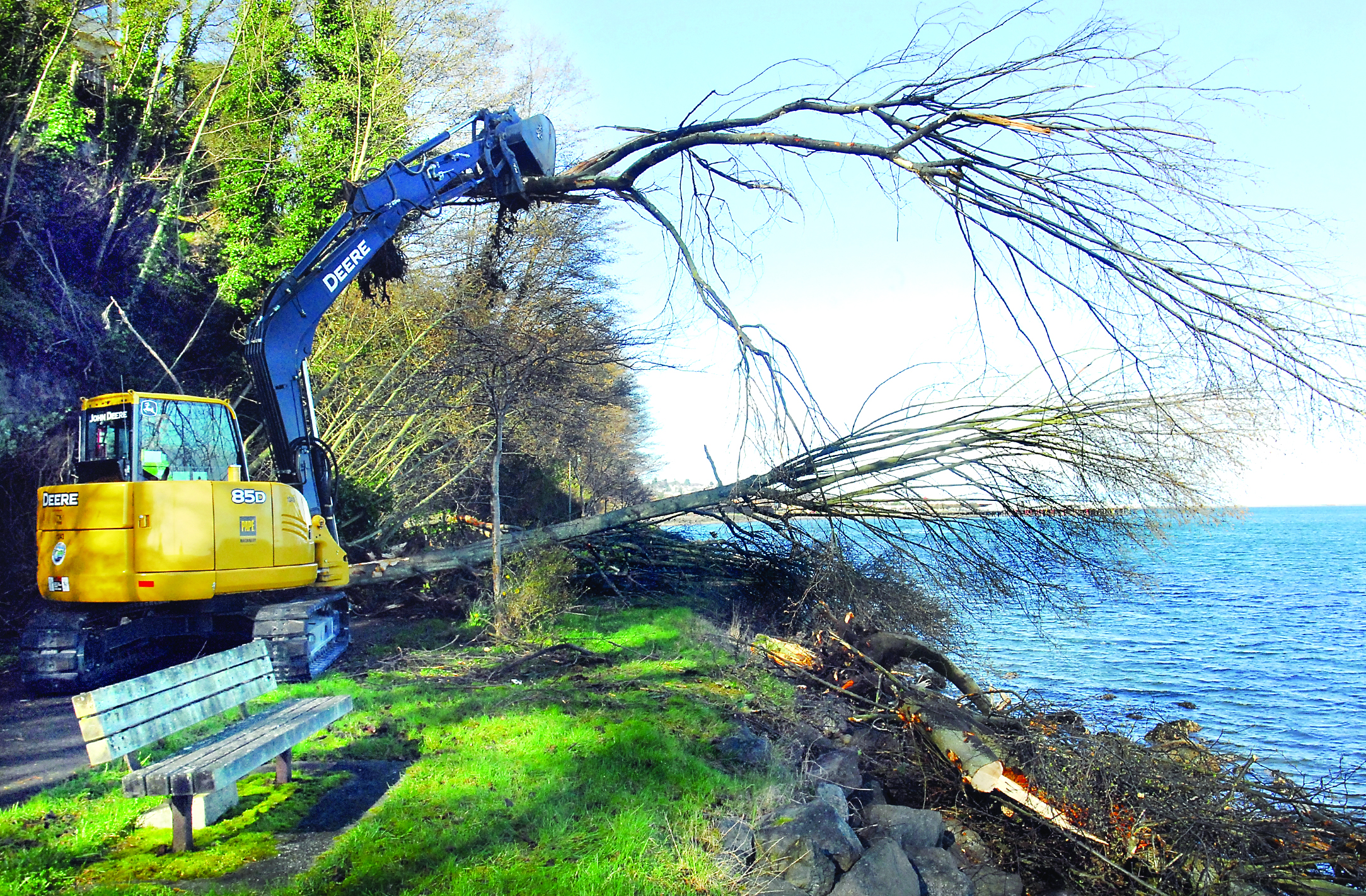 An excavator moves a tree to clear a section of the Waterfront Trail in Port Angeles on Thursday after a slide forced the closure of the trail.  Keith Thorpe/Peninsula Daily News