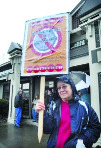 Linda Crane of Port Angeles holds up a sign against the deployment of smart meters during an informational protest outside Port Angeles City Hall.  Keith Thorpe/Peninsula Daily News