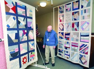 Clallam County Historical Society volunteer Lee Porterfield looks over a pair of quilts that a part of an exhibit on quilting and handicrafts now on display at the societys Museum at the Carnegie.  -- Photo by Keith Thorpe/Peninsula Daily News