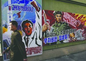 A North Korean man walks past propaganda posters in Pyongyang