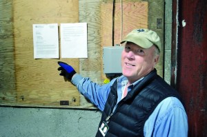 Thomas Ash displays the state-issued license he received April 1 to begin growing the first legal recreational marijuana on the North Olympic Peninsula inside an old dairy barn at Dungeness.  Joe Smillie/Peninsula Daily News
