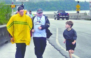 Special Olympics runners Michael Uren of Port Ludlow and Garet Bonham of Sequim are challenged by Samuel Holmes