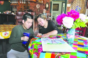 Mick Suwannalerd and Rosie Itti get Khu Larb Thai/Little Rose Restaurant ready for the Taste of Port Townsend on Thursday with new tablecloths purchased from Whats Cookin Kitchen Store in Port Townsend.  Elizabeth Becker/Seaport Photography