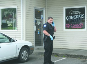 Forks Police Officer Todd Garcia is shown outside Pacific Pizza during Mondays investigation.  -- Photo by Lonnie Archibald/for Peninsula Daily News