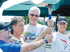 Members of the Cowlitz Valley Runners Club accept the torch for the Sri Chinmoy Oneness-Home Peace Run as it passed through Southwest Washington on Sunday. Runners will be on the North Olympic Peninsula today.  John Markon/The [Longview] Daily News