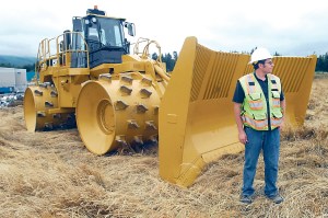 Port Angeles Public Works Inspector Jeremy Pozernick stands next to a trash compactor at the former landfill in Port Angeles. Keith Thorpe/Peninsula Daily News