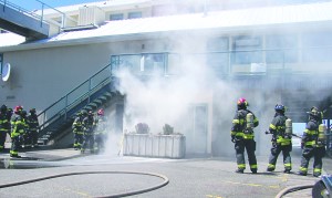 Smoke billows from a storage battery room at The Landing mall on the Port Angeles waterfront as firefighters determine the best way to extinguish the smoky fire that forced evacuation of the large commercial building. Keith Thorpe/Peninsula Daily News