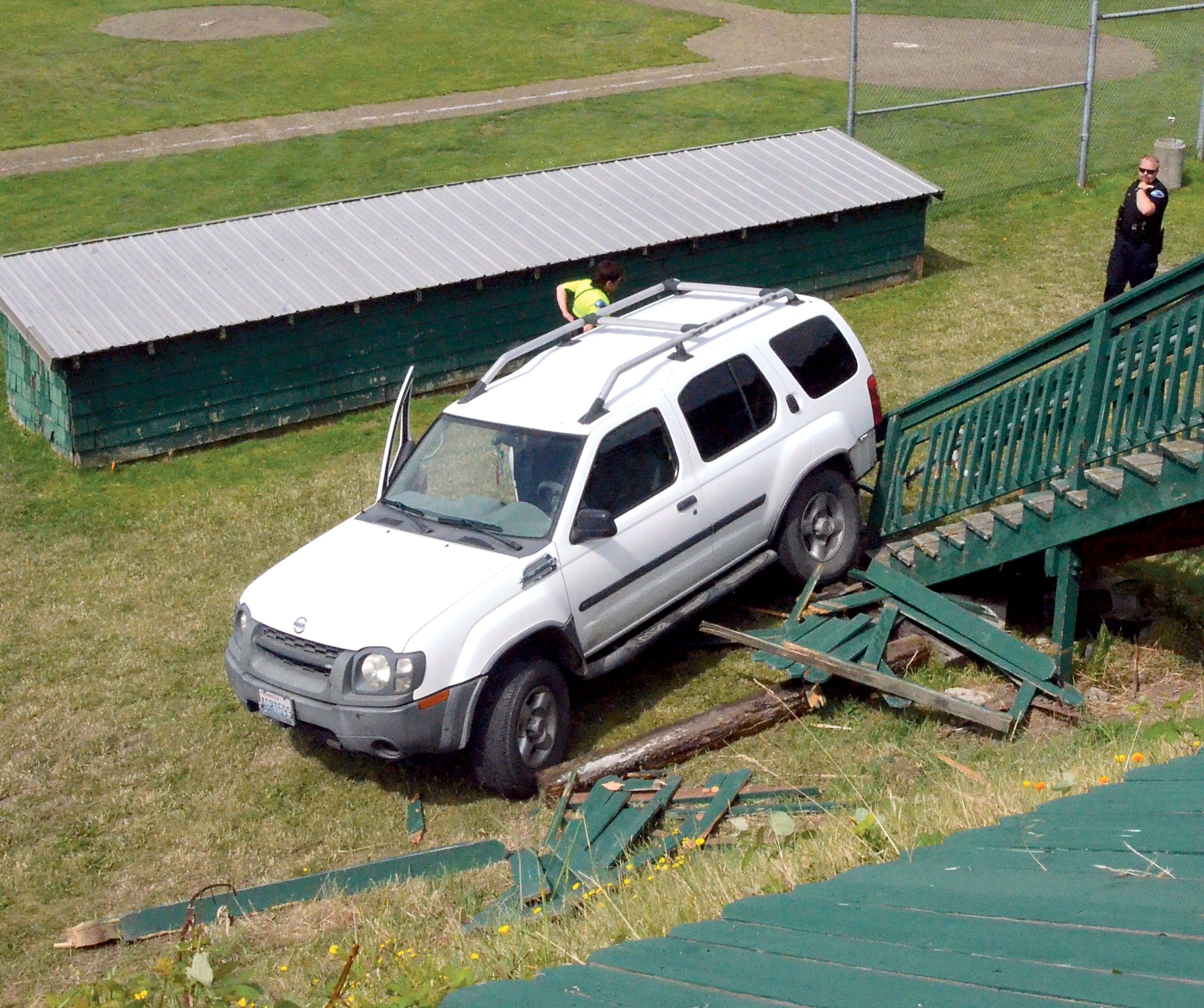 This 2003 Nissan Xterra rests against a damaged staircase at Memorial Field in Port Townsend after backing through a fence and rolling down an embankment onto the athletic field.  Charlie Bermant/Peninsula Daily News