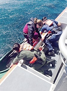 Crew members of a 45-foot response boat-medium based at Air Station/Sector Field Office Port Angeles pull two kayakers onto their boat Tuesday morning. U.S. Coast Guard