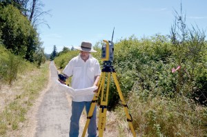 Surveyor Brian Van Aller takes measure of the area that will be used as a right of way connecting Howard Street and Discovery Road.  Charlie Bermant/Peninsula Daily News