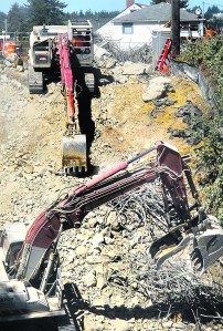 Excavators continue removing debris from the demolished bridge over Peabody Creek on Wednesday.  -- Photo by Keith Thorpe/Peninsula Daily News