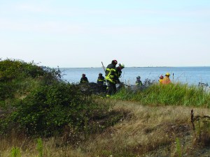 Port Angeles Fire Department and Clallam County Fire District No. 2 firefighters work to mop up a brush fire on the bluffs of the Rayonier Mill property just west of Ennis Creek in Port Angeles. — Arwyn Rice/Peninsula Daily News