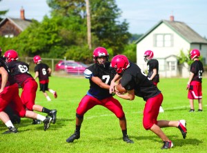 Port Townsend quarterback Jacob King (7) hands off to Liam Anderson during practice. Steve Mullensky/for Peninsula Daily News