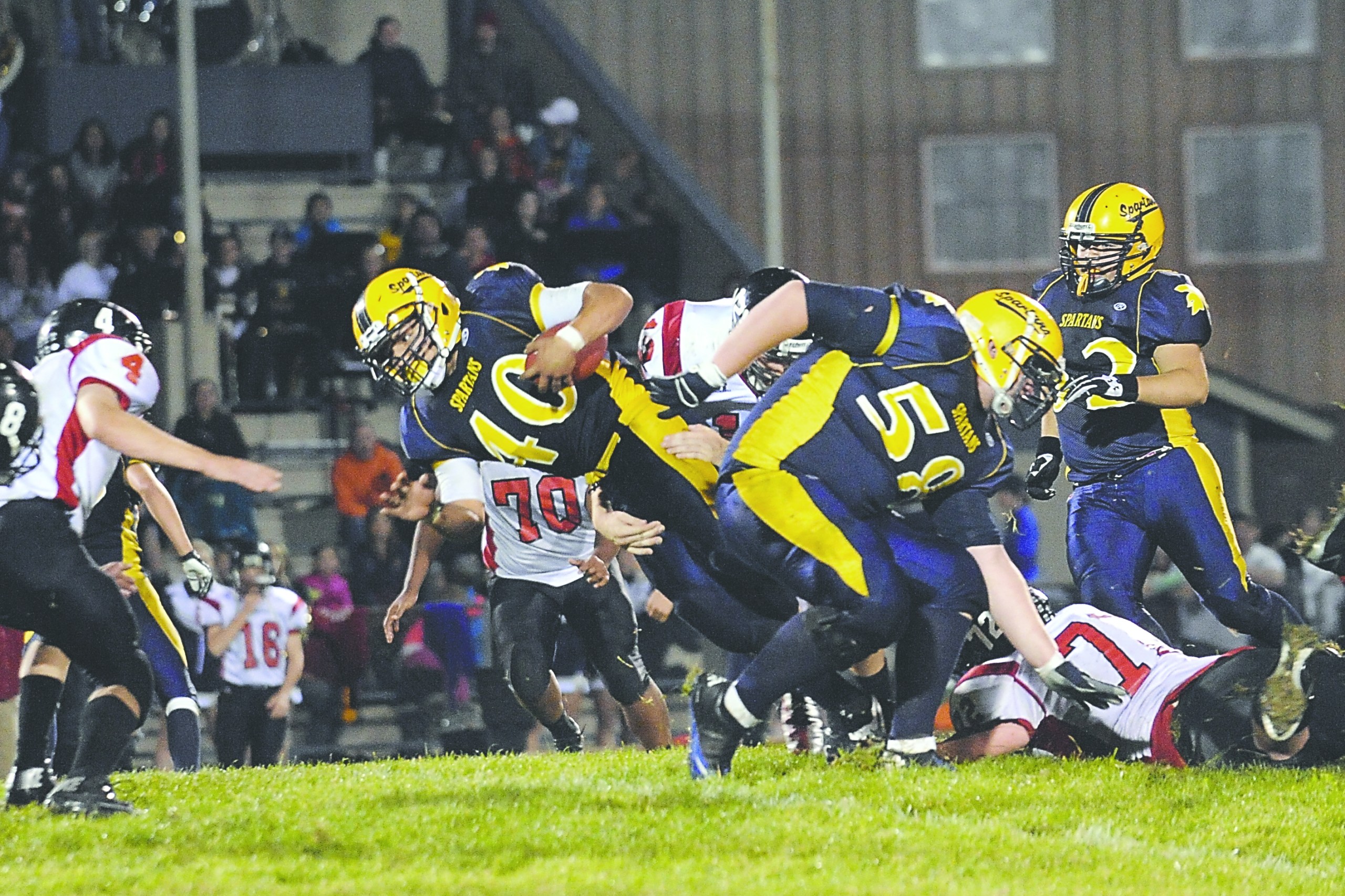 Forks running back Dimitri Sampson (40) plows through the middle of Tenino's defensive line with help of teammate Tanner Robison (58). Lonnie Archibald/for Peninsula Daily News