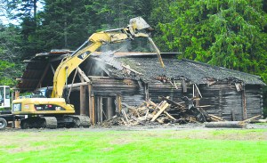 An excavator tears pieces from the longhouse in Lincoln Park in Port Angeles on Tuesday as the building is demolished. To see whats left Wednesday