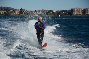 Port Angeles resident Ron Rogers waterskis Sunday with Victoria in the background. Jay Cline/for Peninsula Daily News