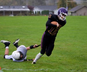 Quilcene quarterback Eli Harrison breaks away from Evergreen Lutheran's Ryan Lorette but loses a piece of his uniform. Steve Mullensky/for Peninsula Daily News