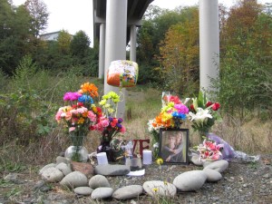 A memorial to Stephanie Diane Caldwell sits late Monday below the Eighth Street bridge from which the 21-year-old woman plunged Saturday. —Photo by Arwyn Rice/Peninsula Daily News