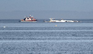 A support boat keeps station with the partially refloated Lady A on Saturday northwest of Three Crabs Road near Dungeness. —Photo by Keith Thorpe/Peninsula Daily News