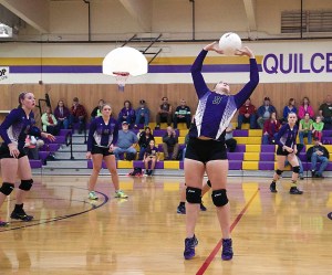 Quilcene's Allison Jones (9) sets the ball for a spike as teammates Megan Weller (11)