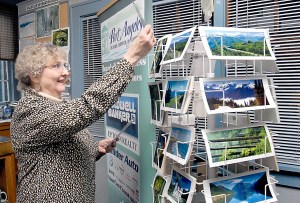 Volunteer Jo-Anne Larson of Port Angeles restocks postcards at the Port Angeles Regional Chamber of Commerce visitor center on the Port Angeles waterfront. Photo by Keith Thorpe/Peninsula Daily News