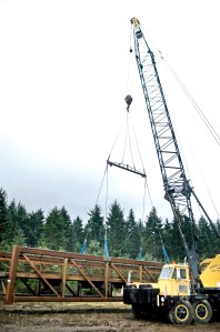 Construction crews are busy Thursday morning preparing this 182-foot-long steel truss span section for installation on the western trestle of the Dungeness River Bridge. Chris McDaniel/Peninsula Daily News