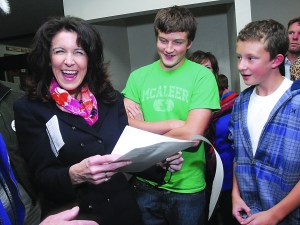 Colleen McAleer shows delight with early election returns at the county courthouse on Tuesday. Among those with her are her son
