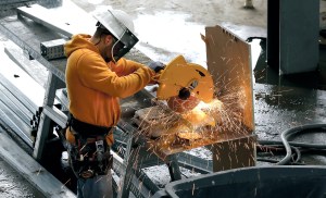 Sparks fly as a worker cuts steel building studs during the construction of a new elementary school in Westport. The Associated Press
