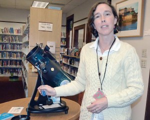 Port Townsend Library assistant Shilah Gould is shown with the telescope that is available for loan.  Charlie Bermant/Peninsula Daily News