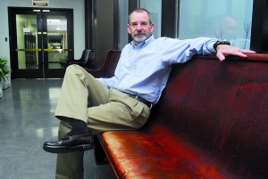 Christopher Melly sits on a hallway bench in the Clallam County Courthouse. He'll be elevated to the Superior Court bench in January. —Keith Thorpe/Peninsula Daily News