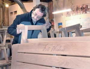 Port Townsend School of Woodworking Executive Director Tim Lawson inspects benches that will be installed on several Fort Worden porches.  Charlie Bermant/Peninsula Daily News