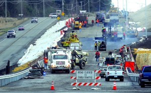 Construction crews work to pave the approach to the new U.S. Highway 101 bridge over McDonald Creek west of Sequim on Thursday as traffic continues to use the old highway.  Keith Thorpe/Peninsula Daily News