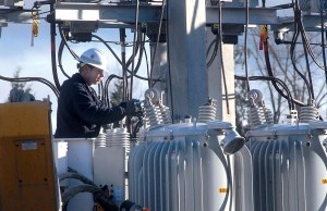 Utility worker Mark Earl of the Clallam County Public Utility District unhooks a damaged power regulator at the Lairds Corner substation west of Port Angeles on Saturday after a copper thief cut grounding cables around the site.  Keith Thorpe/Peninsula Daily News