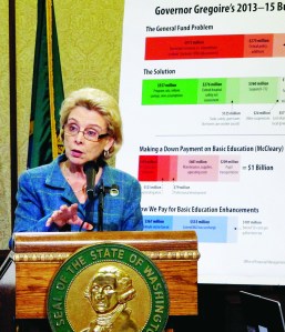 Gov. Chris Gregoire discusses her state budget proposal in front of a chart outlining problems and her proposed solutions.  -- Photo by The Associated Press