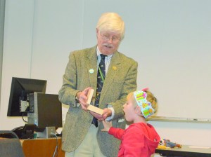 County Commissioner John Austin shows his four-year-old grandson Aaron Maziak the rubber spider staff presented Austin in honor of his retirement.  Charlie Bermant/Peninsula Daily News