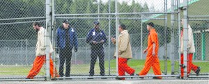 Inmates walk past correctional officers at the Washington Corrections Center in Shelton in February 2011.  The Associated Press