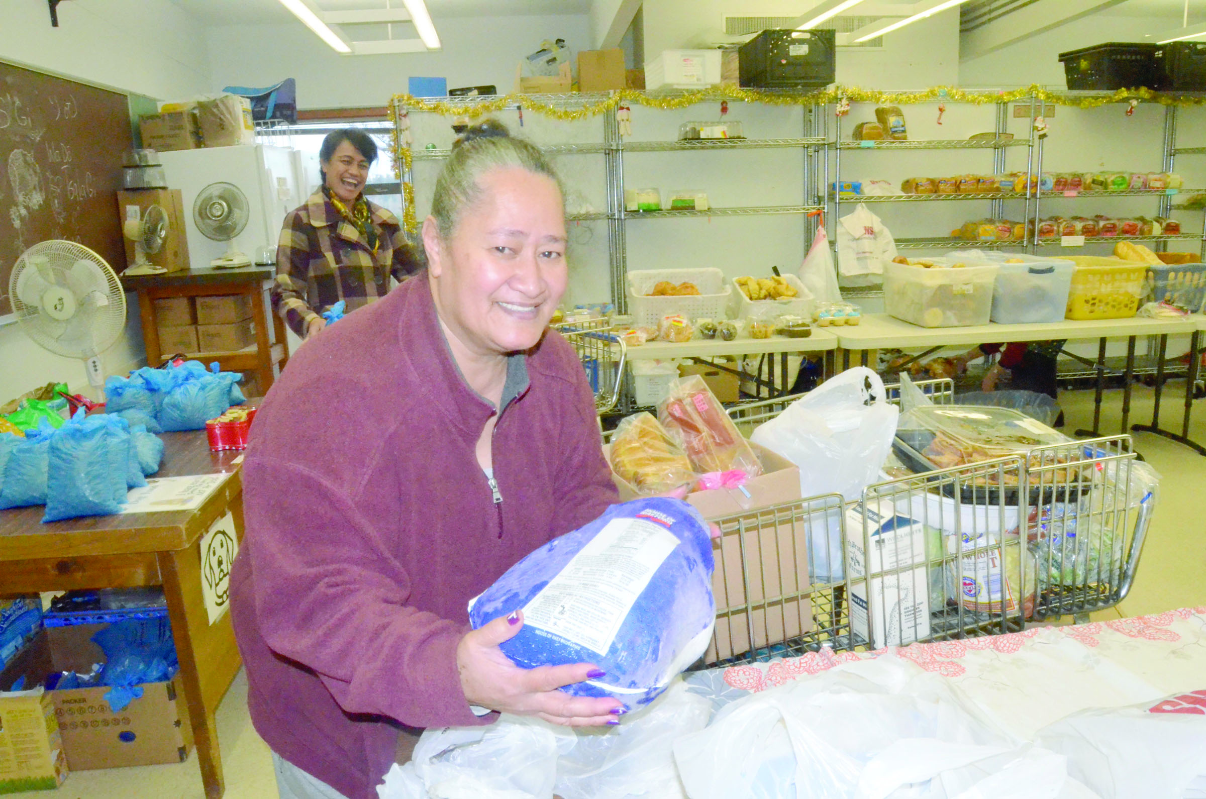 Merita Tavoi of Port Townsend loads a turkey on her cart at the food bank on Monday. Photo by Charlie Bermant/Peninsula Daily News